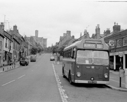 Warkworth Castle Street with bus for Alnwick, 1960s